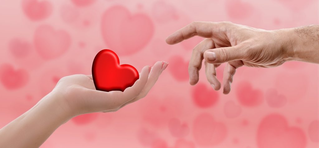 Sharing the love - woman's hand sharing a red heart