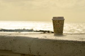 disposable coffee cup by the beach
