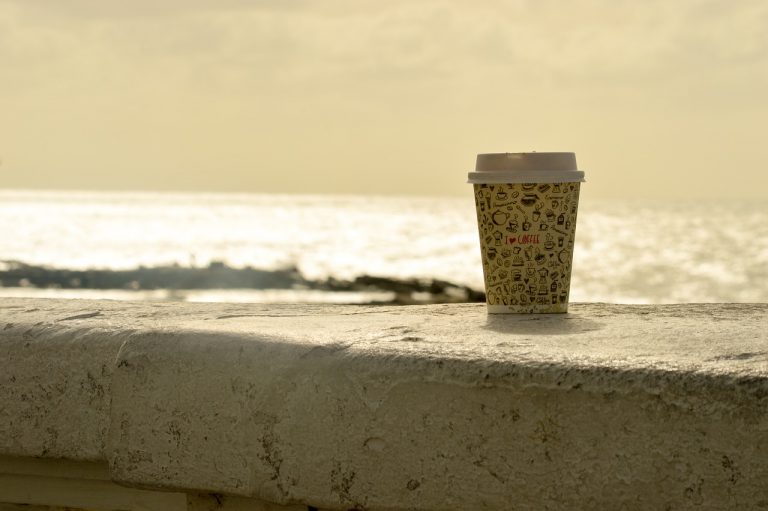 disposable coffee cup by the beach