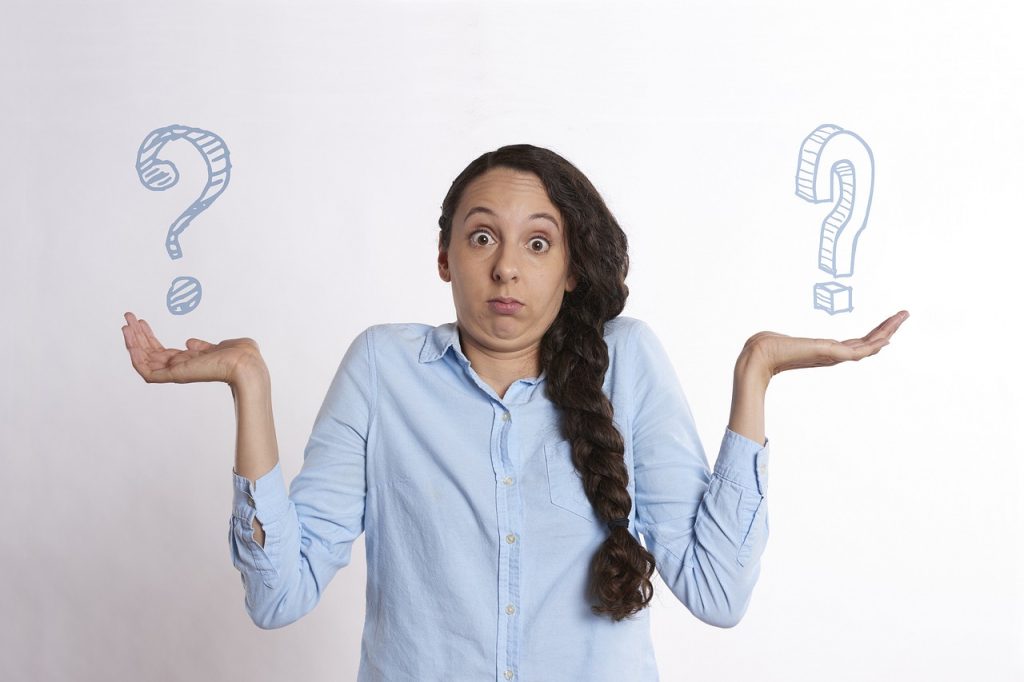 Woman shrugging with question marks around her