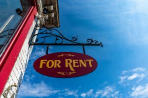 A "For Rent" sign hangs from the front of a business.