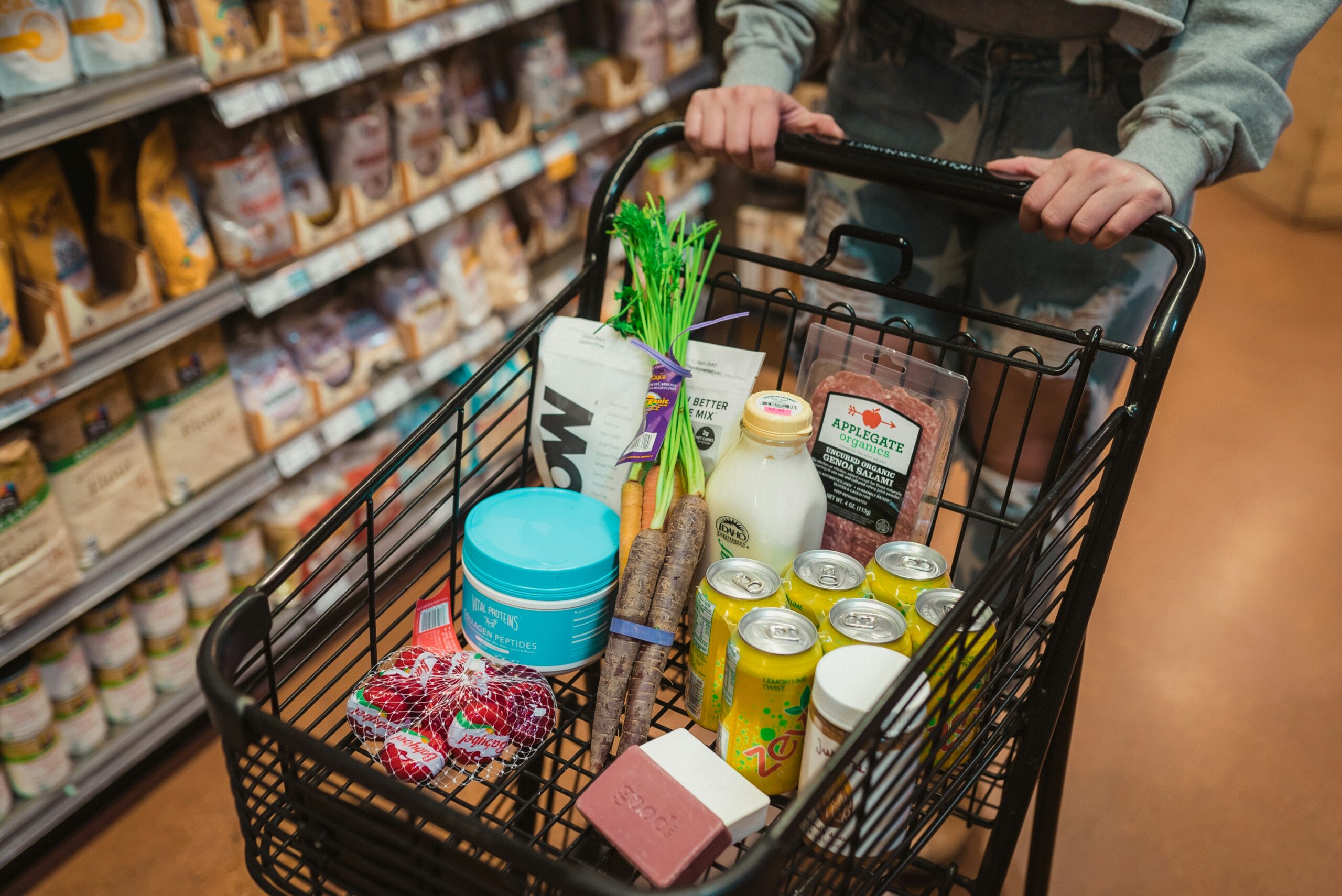 A customer pushes a shopping cart in the grocery store.