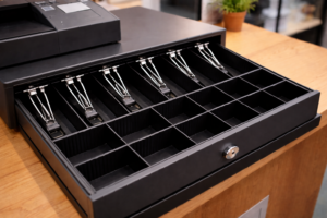A black cash register drawer sits empty of any money.