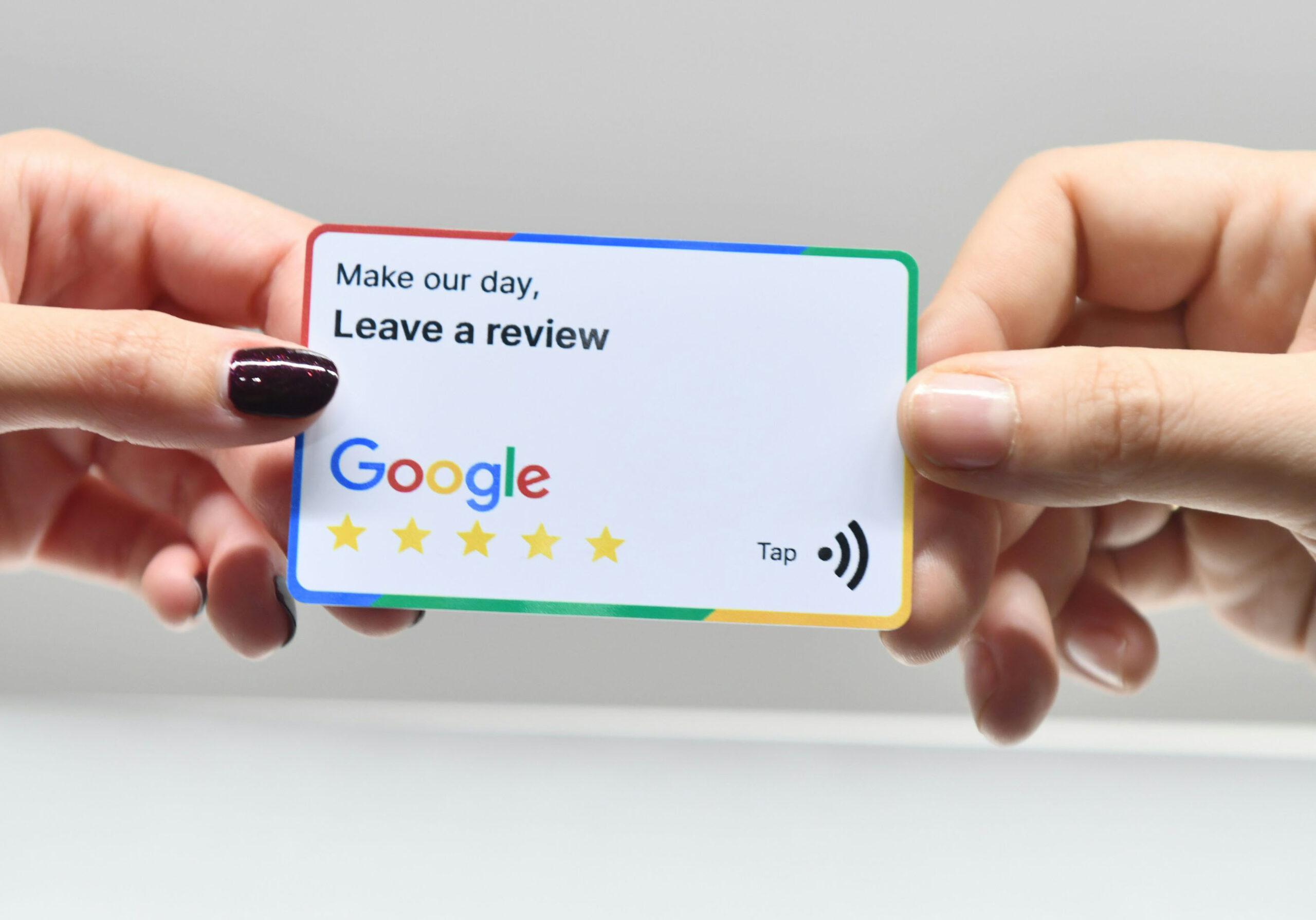 Hands holding a card requesting a Google review.