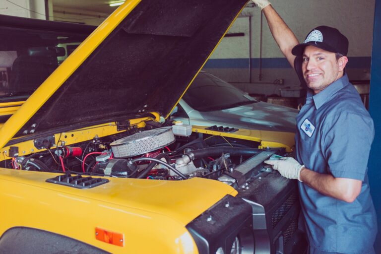 A mechanic works on a car's engine.