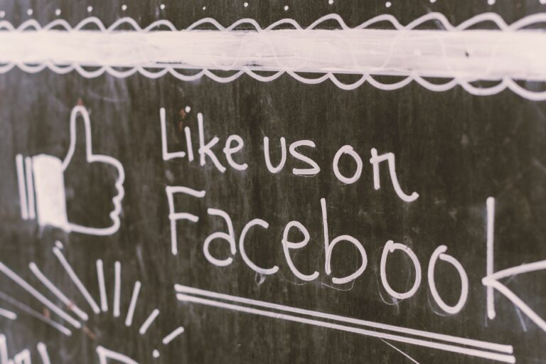 A chalkboard with "Like Us On Facebook" written on it, showing the differentiation between old-school marketing and digital advertising.