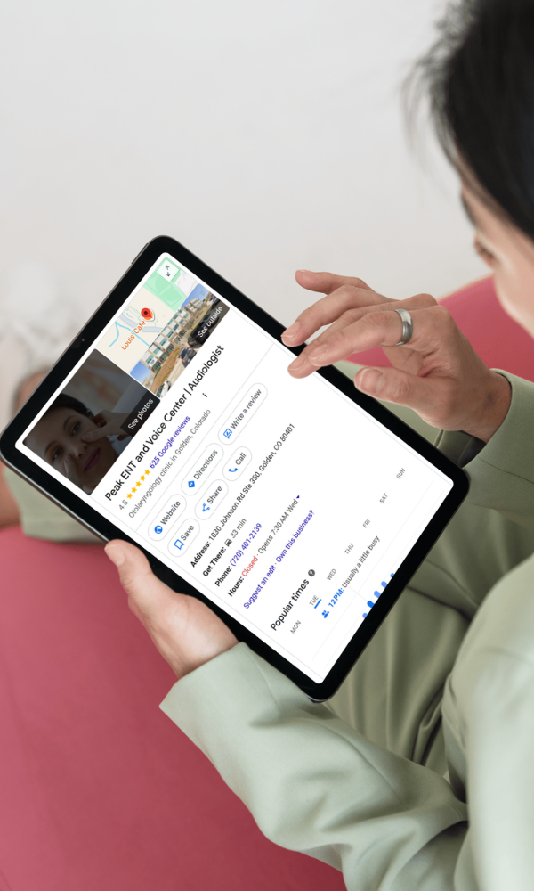 Person looking at Peak ENT Google Business Profile on a tablet
