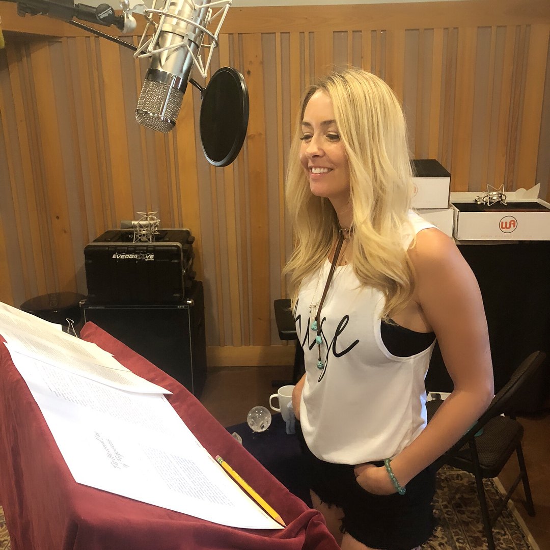 Author Danette May smiling at the studio microphone with her script on the stand, recording her audiobook The Rise at Evergroove Studio