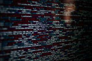 Lines of colorful web code on a dark screen, with syntax highlighting in red, blue, and white.