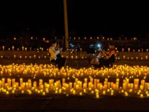 A string quartet playing at night, surrounded by hundreds of glowing candles at Belmar Park in Lakewood, Colorado