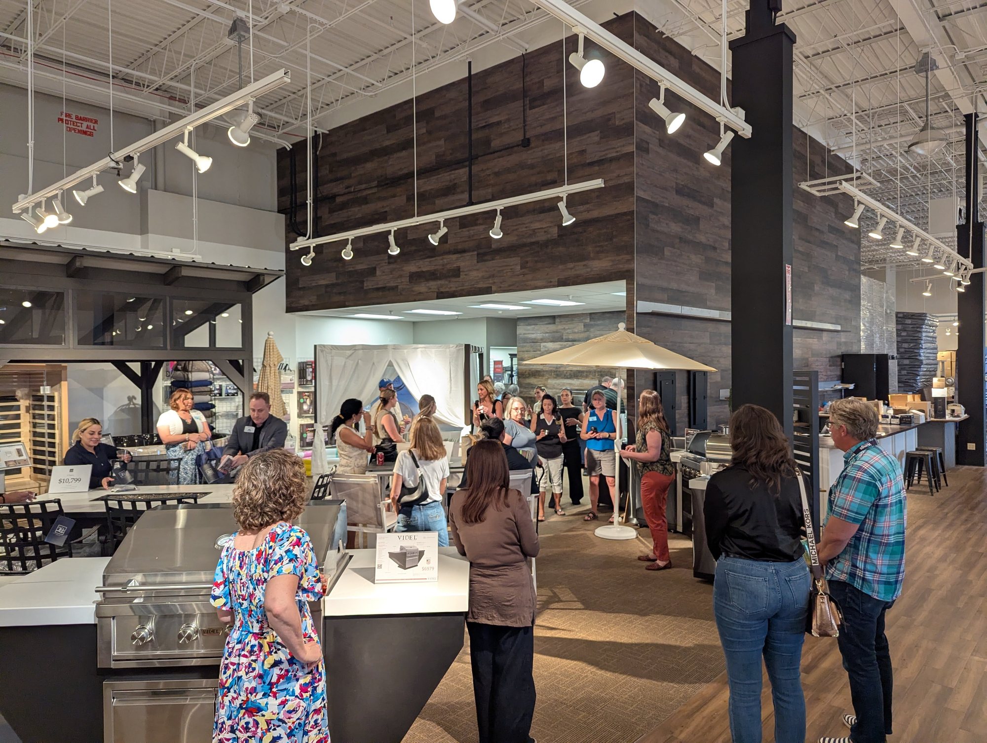 Chamber members gathered in a showroom of outdoor kitchens, grills and patio furniture