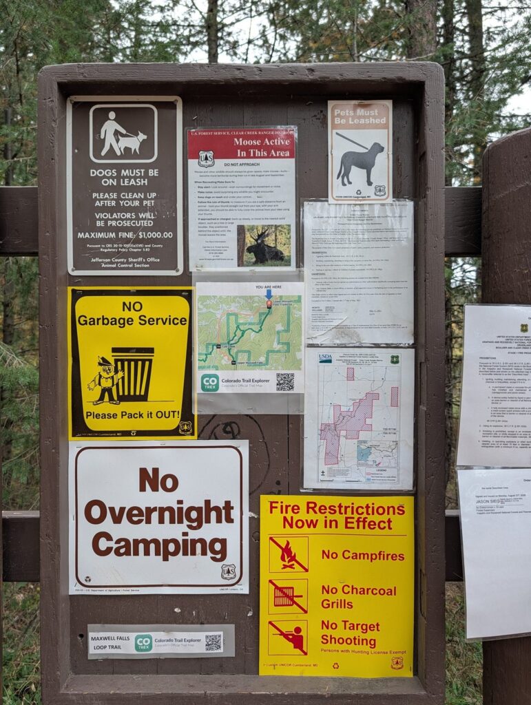 The lower trailhead kiosk at Maxwell Falls, with signs for the leash law, moose in the area, no garbage service, no overnight camping and fire restrictions, plus a Colorado Trail Explorer map.